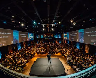 Conference speaker on stage with audience.